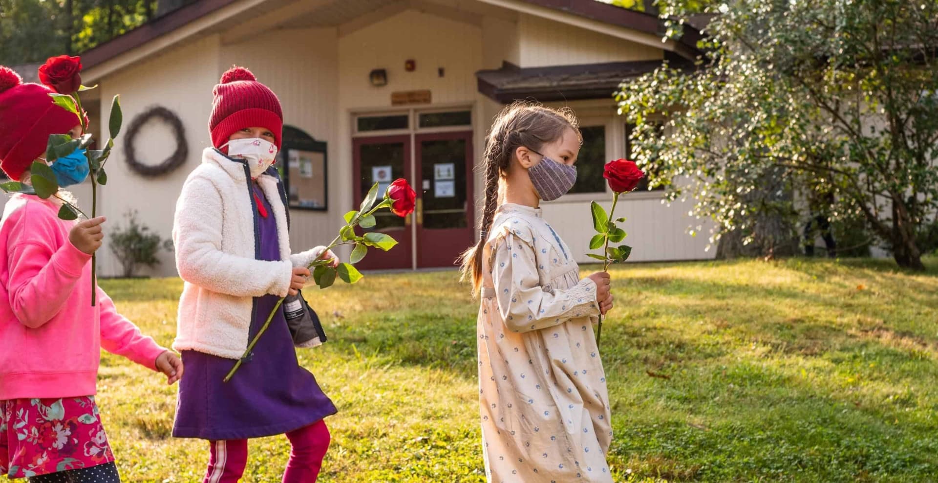 Girls walking holding roses.