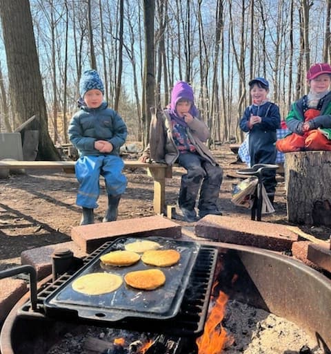 Kids sitting cooking pancakes.