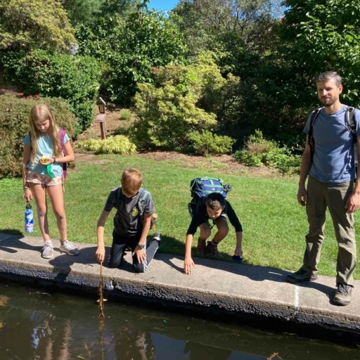 Kids bending over water.